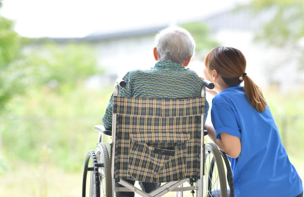 【画像】車いすの高齢者と介護スタッフの後ろ姿